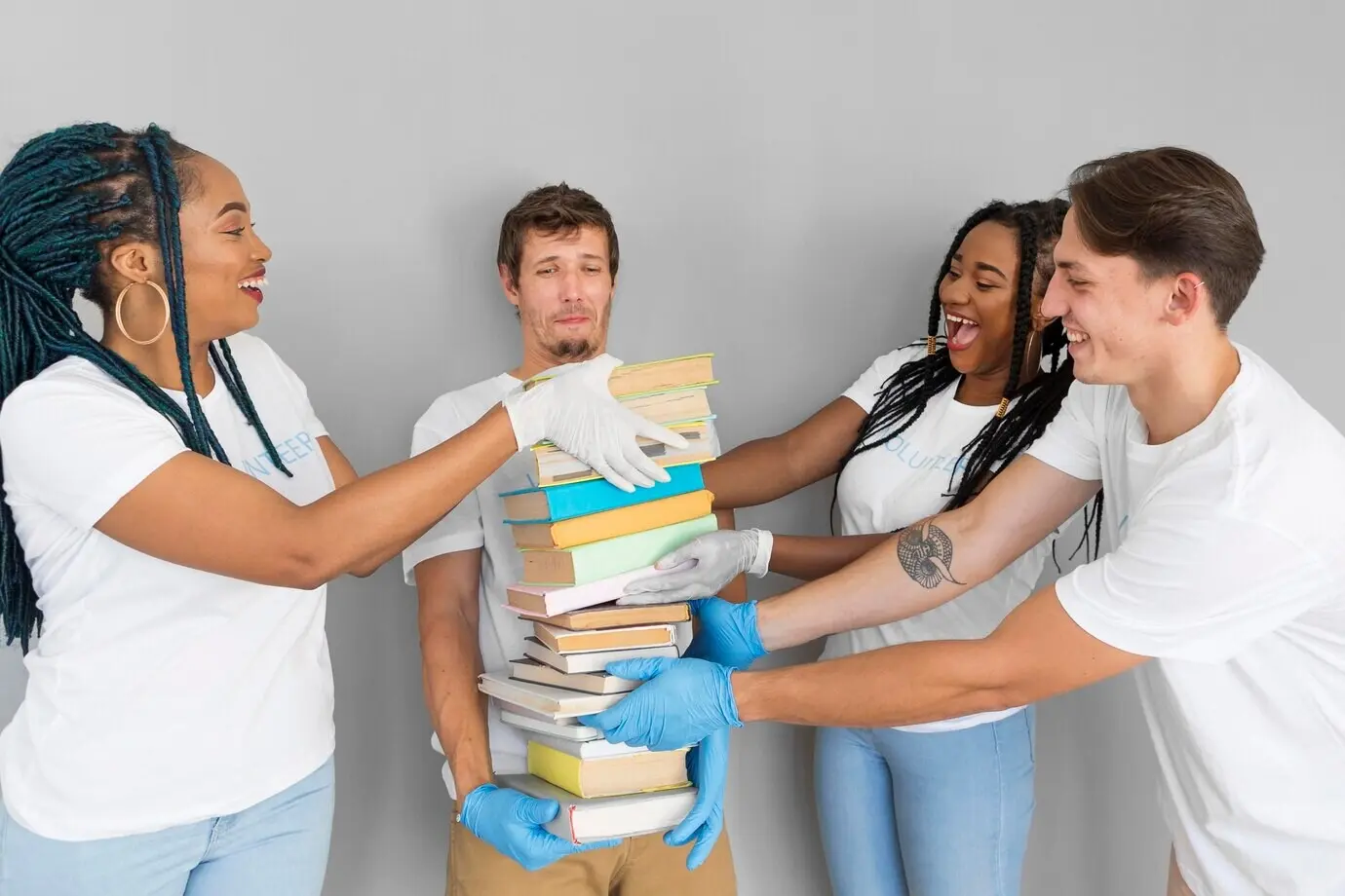 Мужчина держит стопку книг, чтобы их пожертвовать.